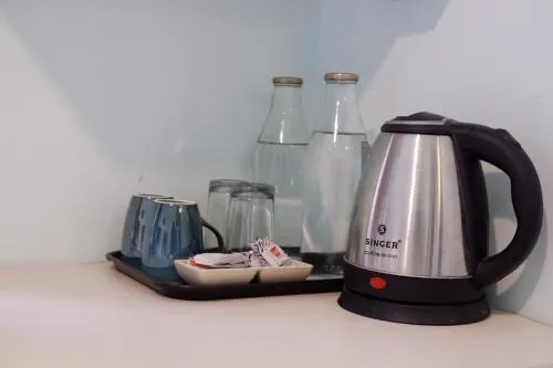 A tea tray with kettle and glasses set out in a room