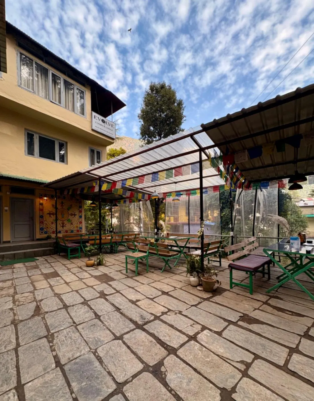 Benches and planters in the courtyard, prayer flags strung overhead