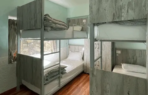 Bunks with towels folded on each bed in the four-bed mixed dorm