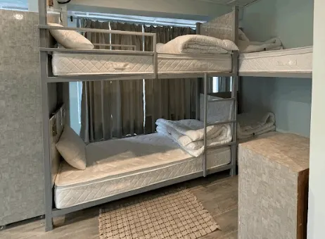 Metal bunk beds made up with fresh linen in the eight-bed dorm