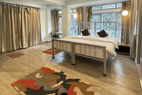 The studio apartment with a double bed and windows along one wall